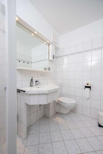 Badezimmer der Ferienwohnung in Winterberg mit Waschbecken, Spiegel und WC