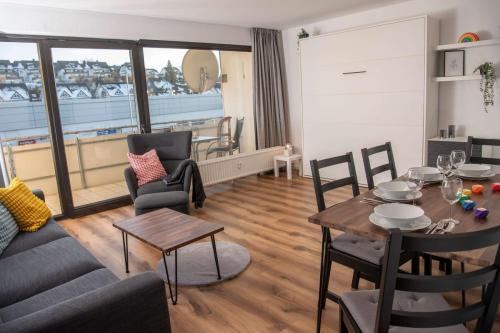 Wohn- und Essbereich der Ferienwohnung in Winterberg mit gedecktem Tisch und Sofa
