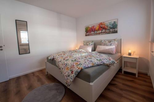 Doppelbett im Schlafzimmer der Ferienwohnung in Winterberg, daneben Spiegel und Nachttisch