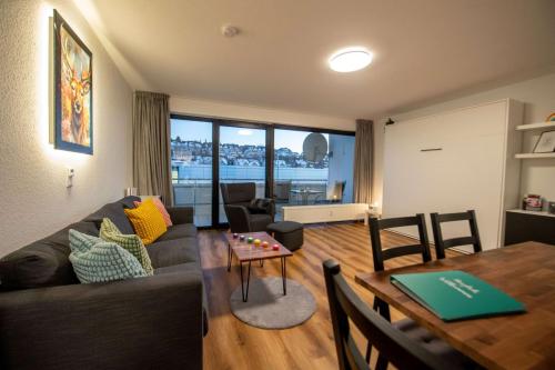 Wohnbereich der Kunterbunten Ferienwohnung in Winterberg am Abend, mit Sofa, bunten Kissen und Esstisch